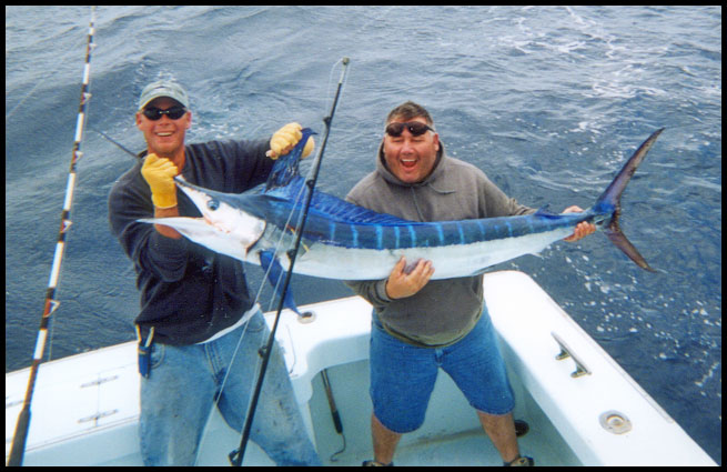 mate and angler with a boated white marlin