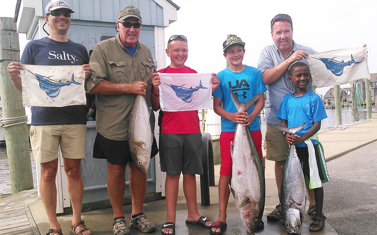 Hatteras deep sea fishing party holding sailfish release flags