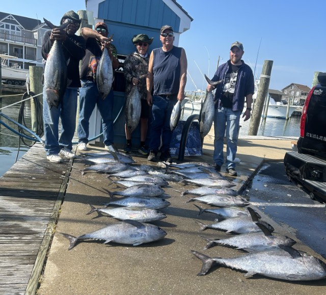 Fishing party at the dock with their catch of tunas.