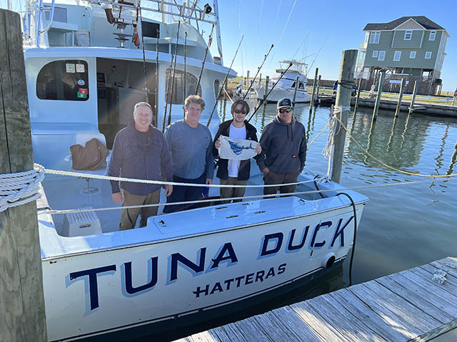 Deep sea anglers pose on the stern of the Tuna Duck with a sailfish release flag